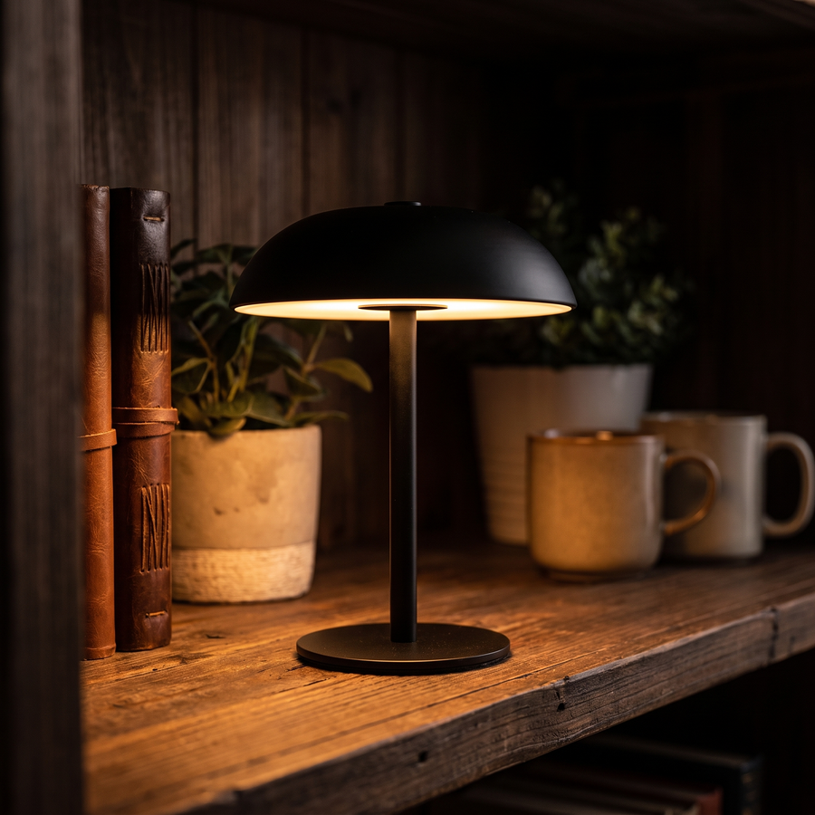 Black mushroom cordless table lamp glowing on a rustic shelf