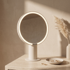 Pearl white LED vanity mirror glowing on a travertine dresser in morning light