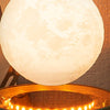 Levitating 3D-printed moon lamp floating and glowing above its illuminated base