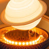 Levitating Saturn lamp with rings floating above the glowing LED base