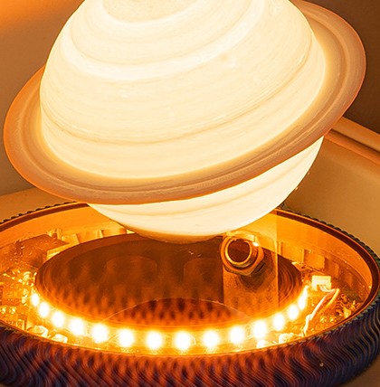 Levitating Saturn lamp with rings floating above the glowing LED base